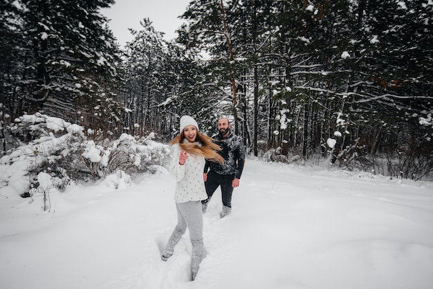 Het spelen van het paar met sneeuw in het bos