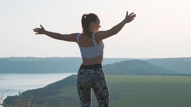 Het sportieve meisje dat op de bergtop staat