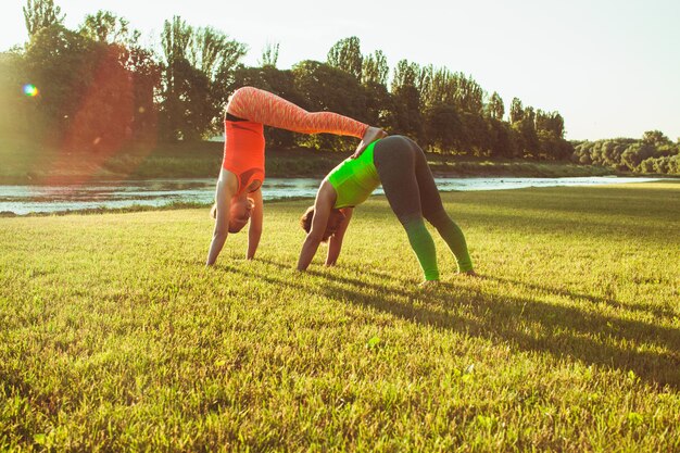 Het stel doet yoga-trainingsactiviteit in de ochtendgloed in het park