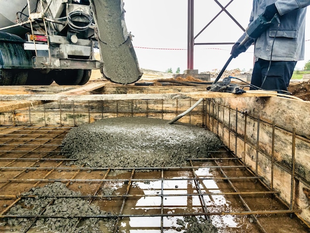 Het storten van de fundering met beton op de bouwplaats monolithische gewapende betonwerken tijdens de constructie van het gebouw