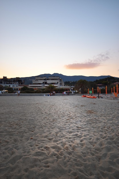 Het strand bij zonsondergang met de bergen op de achtergrond