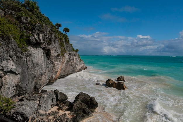 Het strand van Tulum is omgeven door rotsen en de oceaan.