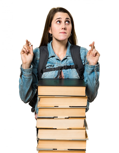 Het studentenmeisje van de tiener met heel wat boeken en met haar vingers kruising