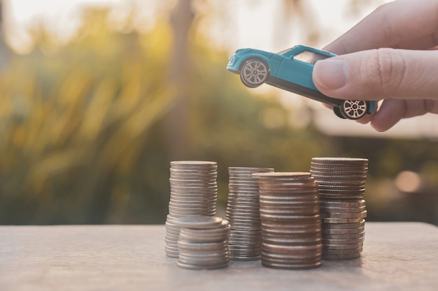 Het stuk speelgoed van de hand auto op muntstapels