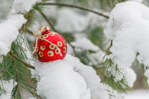 Het stuk speelgoed van het rode Nieuwjaar op een sneeuwspar