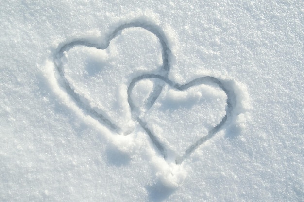 Het symbool van twee harten getekend op de sneeuw