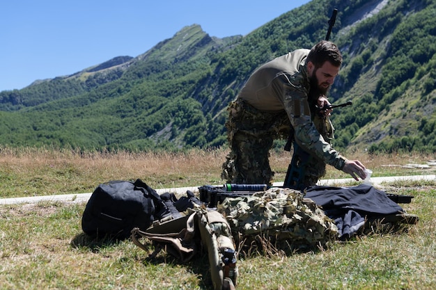 Foto het team van speciale operaties-soldaten bereidt tactische en communicatie-uitrusting voor op een actiegevecht. lange afstand sluipschutterteam bij het controleren van uitrusting voor actie.