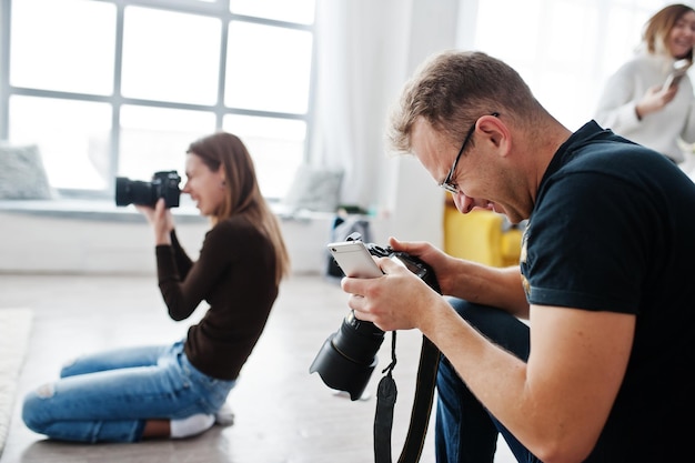 Het team van twee fotografen die op studio schieten Professionele fotograaf op het werk