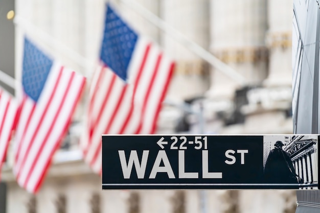 Het teken van Wall Street in de stads financiële economie en bedrijfsdistrict van New York met nationale de vlagachtergrond van Amerika. Beurshandel en wisselzone.