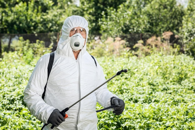 Het thema van de industriële landbouw. Een persoon spuit giftige pesticiden of insecticiden op een plantage. Wiet controle.