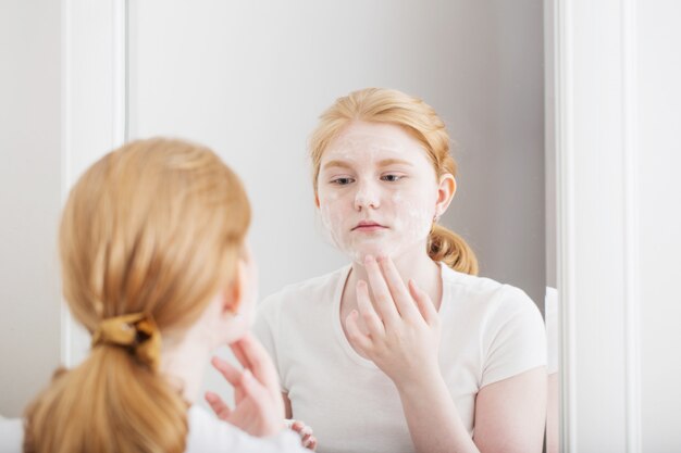 Het tienermeisje zet gezichtsmasker op