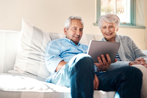 Het tijdperk van slimme technologie omarmen Shot van een senior koppel dat samen een digitale tablet gebruikt in hun woonkamer thuis