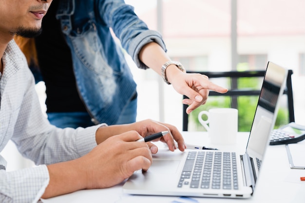 Het toevallige zakenman en team werken bespreken bedrijfs marketing plan op laptop in modern huisbureau