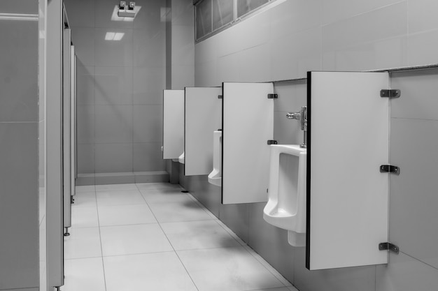 Het toilet van de mens met toiletzicht door urinoirs op het oude toilet in zwart-witte toon op kantoor.