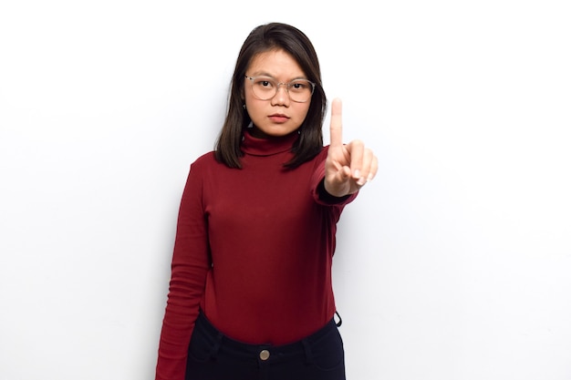 Het tonen van een vinger van jonge mooie Aziatische vrouwen jurk rood shirt geïsoleerd op een witte achtergrond