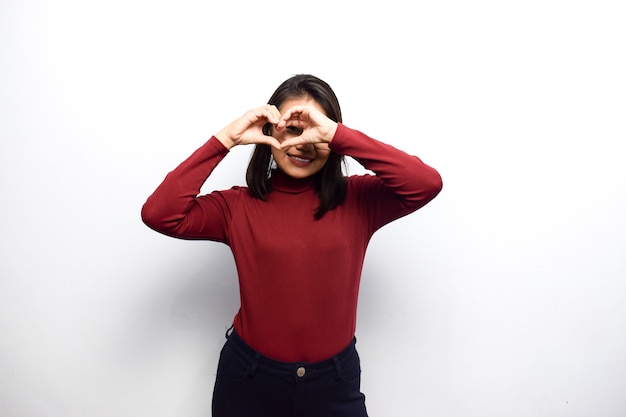 Het tonen van hart of liefdesuitdrukkingsteken van jonge mooie Aziatische vrouwen die een rood overhemd kleden