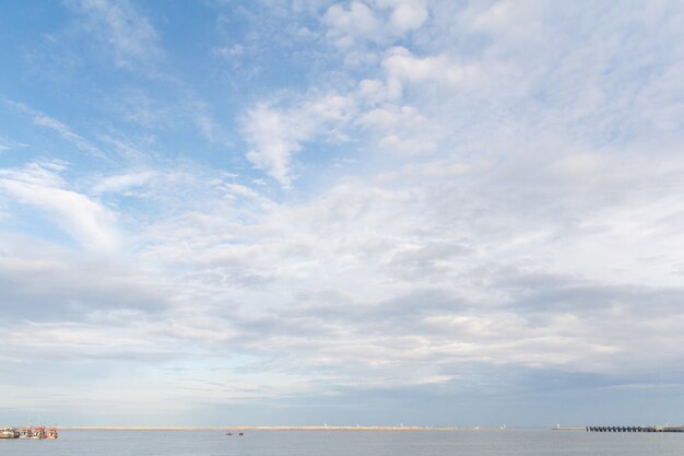 Het uitzicht op zee en blauwe lucht met een wolkje.