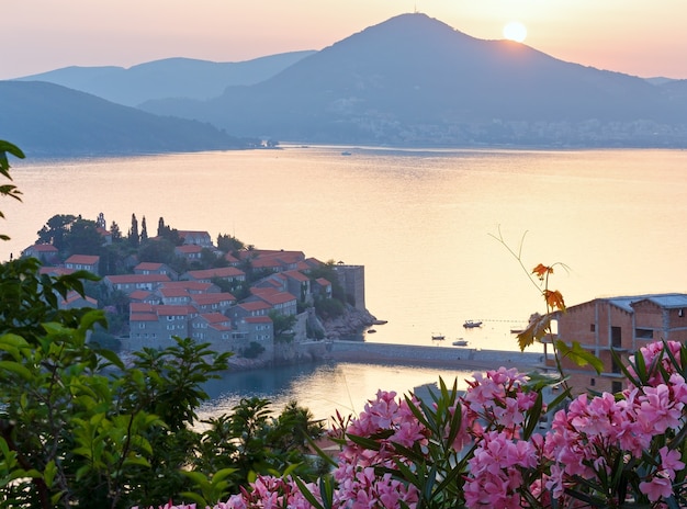 Het uitzicht vanaf het terras bij zonsondergang over het zee-eilandje Sveti Stefan