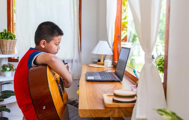 Het verhaal van een jongen die naar een notebook kijkt terwijl hij zich voorbereidt om thuis gitaar te oefenen