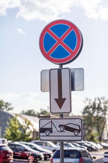 Het verkeersbord verbiedt stoppen tegen de achtergrond van gebouwen en auto's Close-up verkeersborden