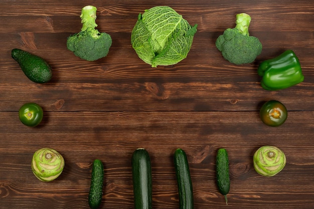 Het verzamelen van groene groenten produceert op een donkere achtergrond broccolini avocado squash chili druiven, onderdeel van een platte overhead set