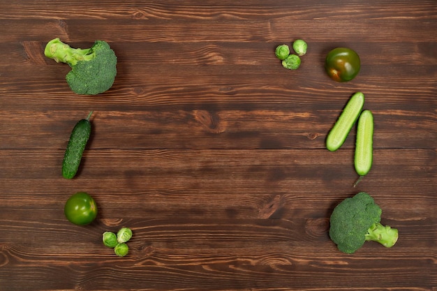 Het verzamelen van groene groenten produceert op een donkere achtergrond broccolini avocado squash chili druiven, onderdeel van een platte overhead set