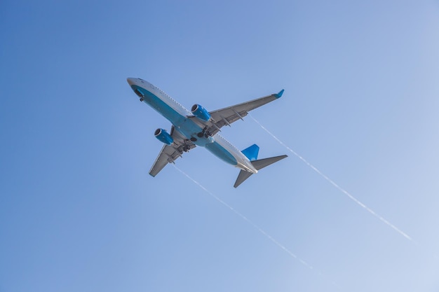 Het vliegtuig vliegt tegen de achtergrond van de blauwe lucht en landt