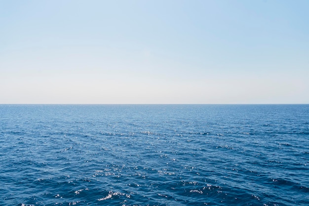 Het vooraanzicht in de ochtendlucht is helderblauw met heldere witte wolken En de oceaan diep indigo bij daglicht Kalm, koel ontspannend Het idee voor een koude achtergrond en kopieerruimte aan de bovenkant