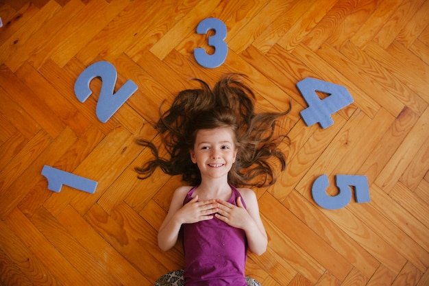 Het vrolijke blondemeisje spelen met aantallen thuis