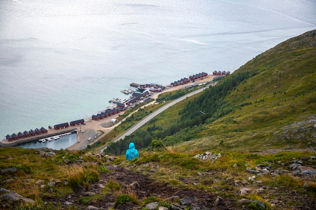 Het wandelaarmeisje zit op rotsen op Offersykammen-sleephoofd en bewondert panorama van lofoten-eilanden, Noorwegen