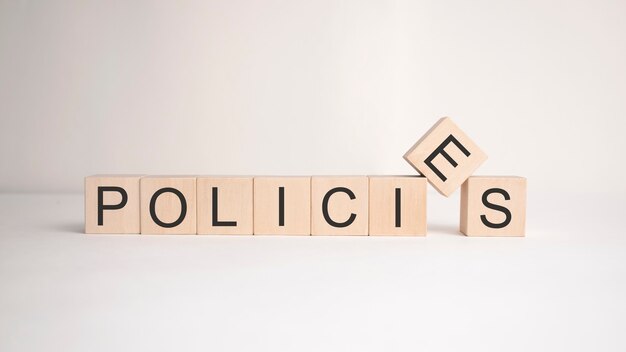 Het woord beleid is geschreven op houten kubussen op een lichte ondergrond