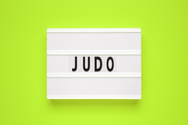 Het woord judo op lightbox isoleerde groene achtergrond