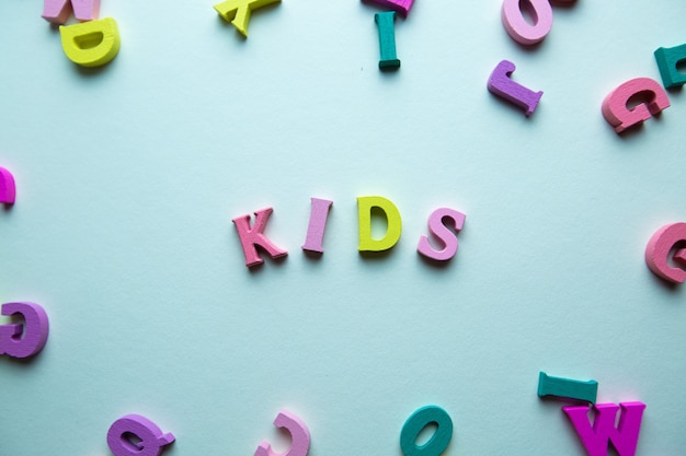 Foto het woord kinderen bestaat uit houten veelkleurige letters op een blauwe achtergrond voor kinderen