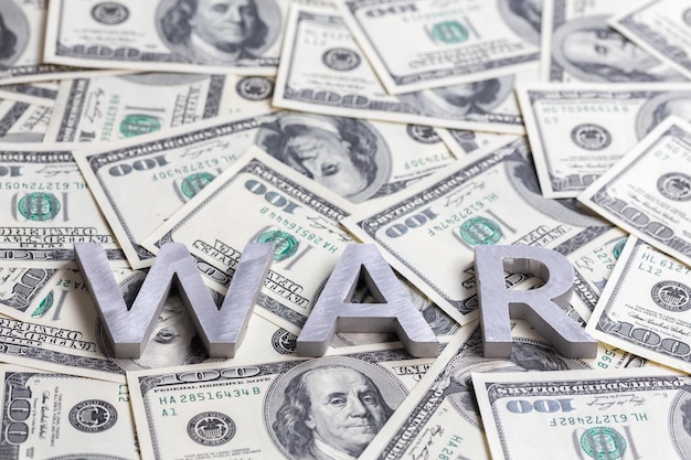 Het woord oorlog gelegd met metalen letters op het mozaïek van de Amerikaanse dollarbankbiljetten