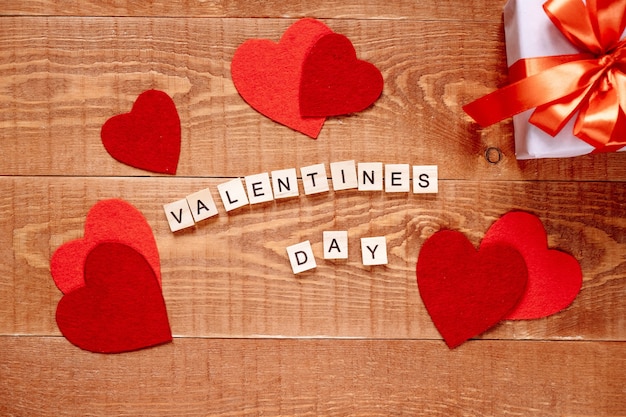 Foto het woord valentijnsdag. liefde op houten blokken op natuurlijke achtergrond. thema van liefde, hart en cadeau.