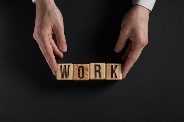 Foto het woord work is geschreven in houten blokjes in zwarte letters op een gele achtergrond