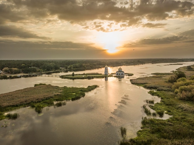 Foto het zachte licht van de opkomende zon verlicht de beroemde ondergelopen kerk in gusintsy, oekraïne