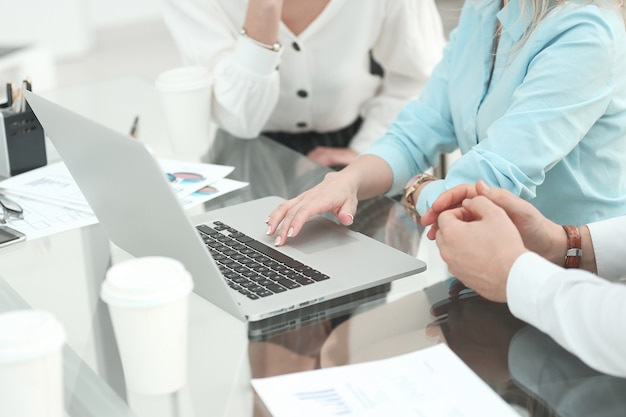 Het zakelijke team gebruikt een laptop om financiële gegevens te analyseren