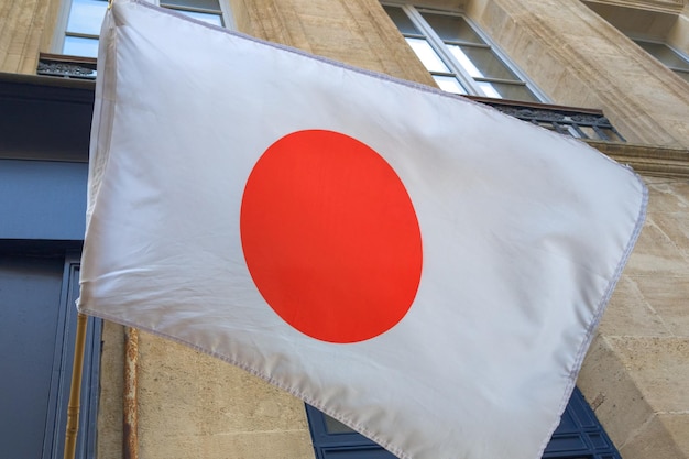 Het zwaaien van de Japanse vlag in de open lucht rood rond en witte achtergrond