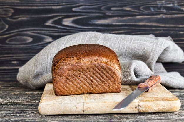 Het zwarte bittere brood van de roggemeel, close-up van voedsel op keuken scherpe raad