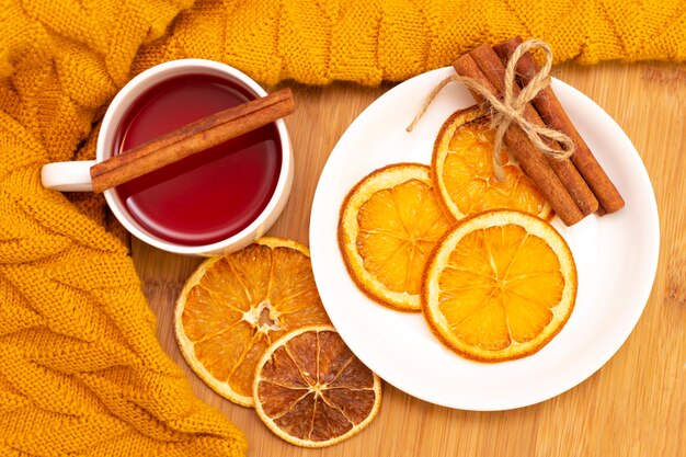 Hete aromatische thee met kaneelstokjes en plakjes gedroogde sinaasappels. op een houten tafel