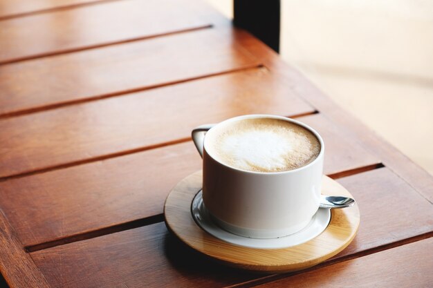 Hete cappuccino op houten lijst, uitstekende stijl