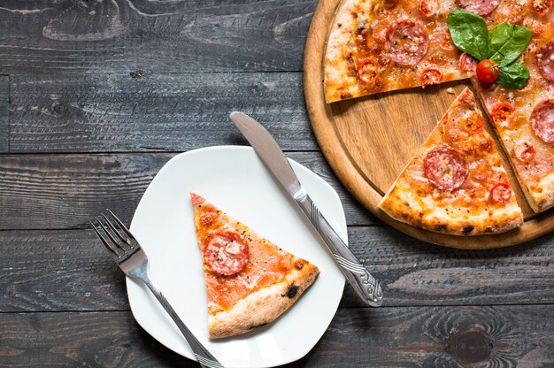 Hete Italiaanse pizza op een rustieke houten tafel.