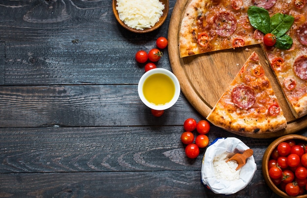 Foto hete italiaanse pizza op een rustieke houten tafel.