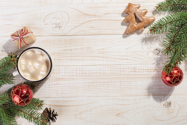 Hete kerstdrank met marshmallows in een ijzeren mok en peperkoekkoekjes, op een witte tafel. , vakantie, wenskaart copyspace.