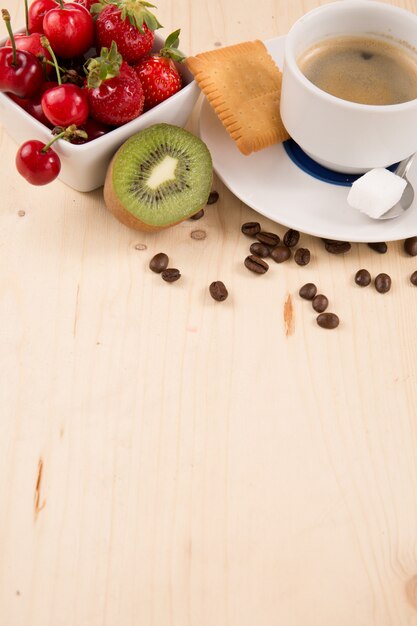 Hete koffie en smakelijke cake en fruit op houten tafel