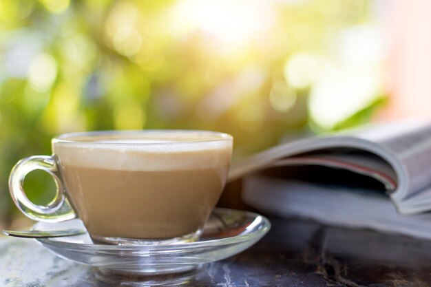 Hete koffie op tafel met boek in de ochtend