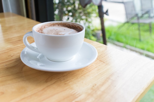 Hete koffiemokaat met schuimmelk in plattelandskoffie