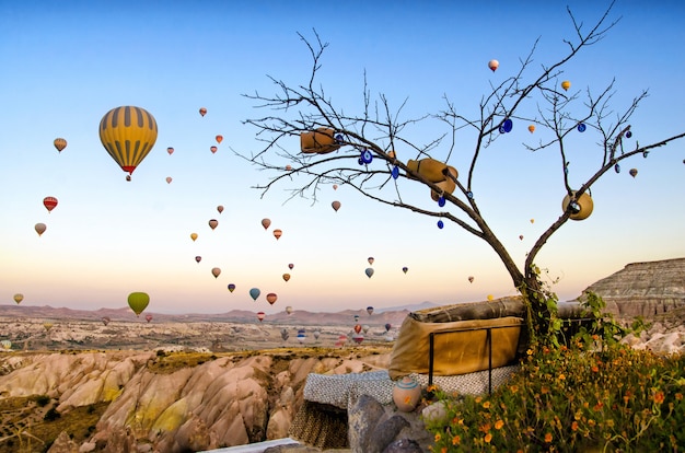 Hete luchtballon die over rotslandschap in cappadocia turkije vliegt