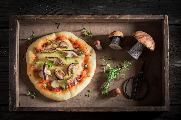 Hete rustieke pizza gemaakt van wilde paddestoelen en kruiden